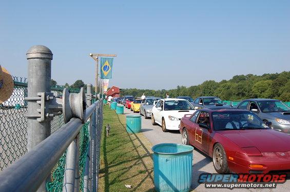 Cars lined up on a track, with a Brazilian flag visible
