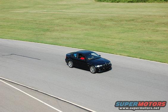 Black 2002 BMW M3 on racetrack, number 98 on door