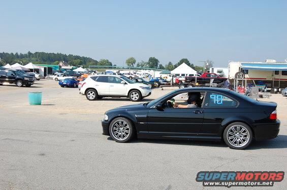 Black 2002 BMW M3 coupe with racing numbers on side window