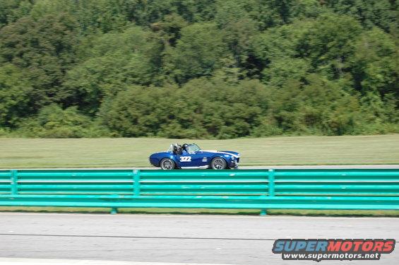 Blue convertible race car with number 322 on side, driving on track