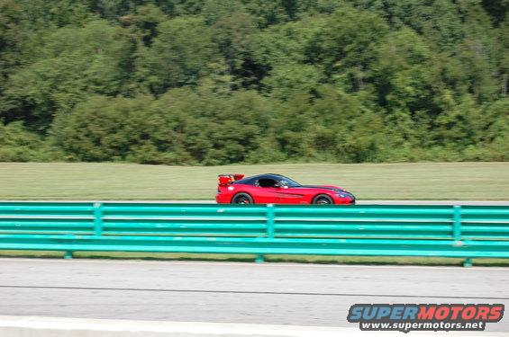 Red sports car with a rear spoiler on a racetrack