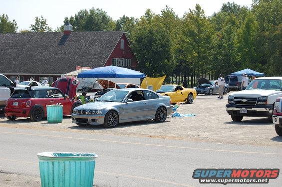 Silver BMW coupe with racing number 70 on the door, viewed from the front-right, parked on gravel