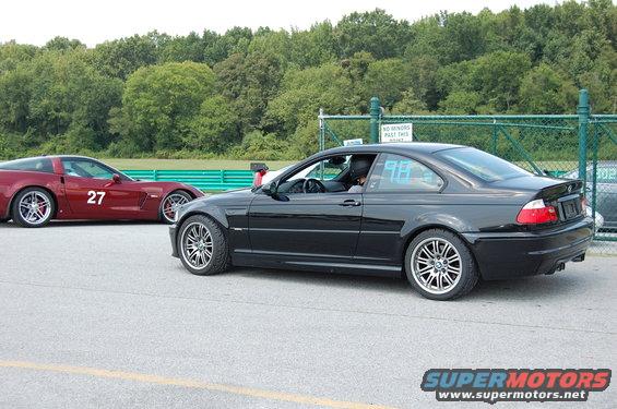 Black 2002 BMW M3 and red Corvette with number 27 on track