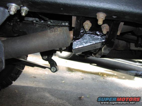 Undercarriage view of vehicle suspension and exhaust pipe