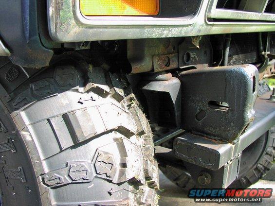 Close-up of a large off-road tire and custom bumper on a vehicle
