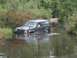 1993 Jeep Cherokee - A black 1993 Jeep Cherokee navigates through a water obstacle, equipped with a snorkel for off-road adventure.
