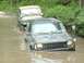 1993 Jeep Cherokee - Two Jeeps navigate a muddy water crossing, with the lead vehicle a snorkel.