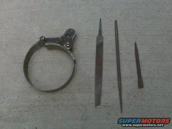 Oil filter wrench and three files on concrete. Supermotors.net logo visible