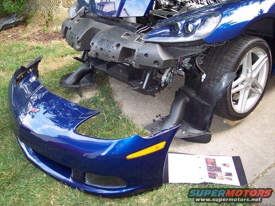 Blue Corvette front bumper removed, car's front end exposed