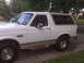 1995 Ford Bronco - Side profile of a white 1995 Ford Bronco, tan lower body trim and running boards.