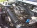 1995 Ford Bronco - The engine bay of a vehicle, showing the intricate network of hoses and wiring connected to the engine block.