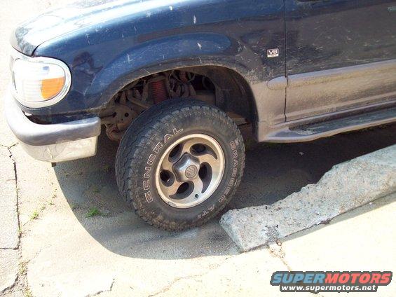 Dark blue 1997 Mercury Mountaineer front wheel and fender with V8 badge