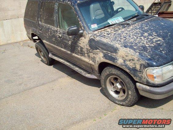 1997 Mercury Mountaineer covered in mud, front passenger side view