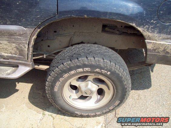 Rear wheel and fender area of a 1997 Mercury Mountaineer. Tire is a General Grabber AT2