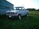2001 Dodge 2500 - A gray Ford Ranger pickup truck is parked on grass next to a metal building with a field in the background.