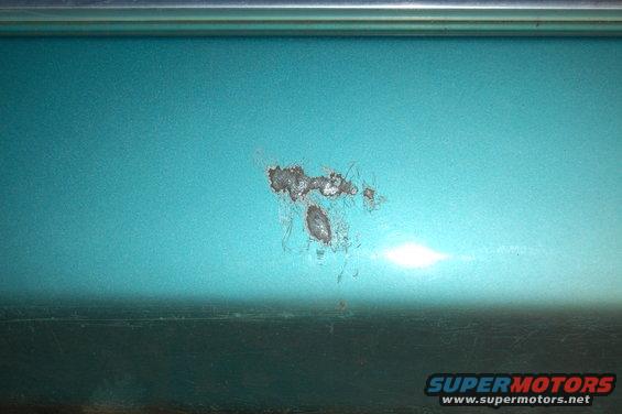 Close-up of rust forming on teal vehicle paint