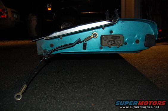 Teal car door latch mechanism with cable attached