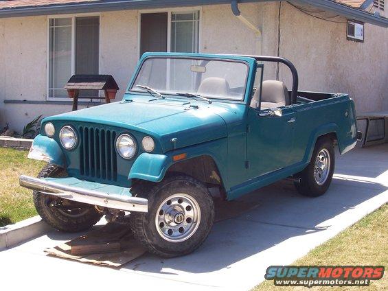 Teal 1970 Jeep Jeepster with chrome bumper and aftermarket wheels, parked on driveway