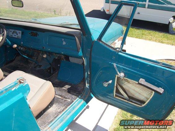 Interior view of a 1970 Jeep Jeepster showing dashboard, seats, and door panel