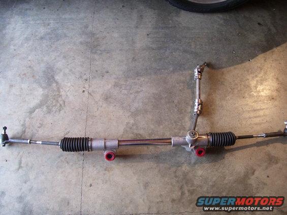 Steering rack and pinion assembly with red bushings and tie rod ends