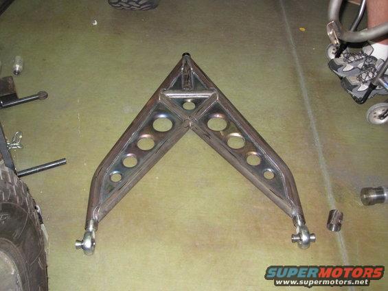 Custom V-shaped metal bracket with circular cutouts and ball joint ends, on a concrete floor