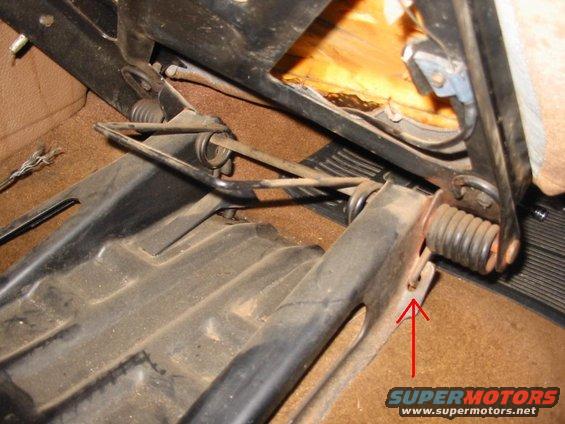 1666690a_img.jpg This is where you pry up. First tilt seat forward. Then remove all four floor mounting bolts. Then slide seat base backwards about one foot. Allow seat back to go forward until pressure is off the spring. Then use a screwdriver to pry up on the spring at the spot shown. After you pry up, slide the notch out to the side. Do both sides and all the pressure will be off the spring. Then remove the seat.