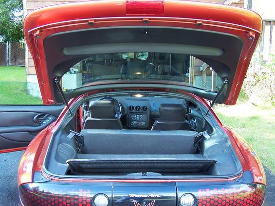 Red 2001 Pontiac Trans Am with open trunk, showing interior and rear badging