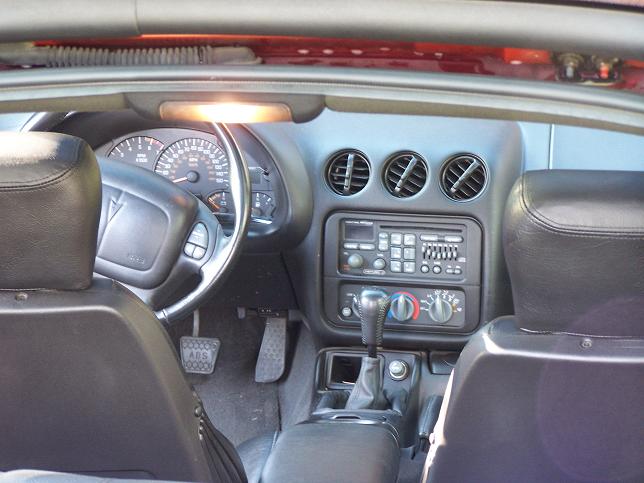 Interior view of a 2001 Pontiac Trans Am showing dashboard, steering wheel, and center console