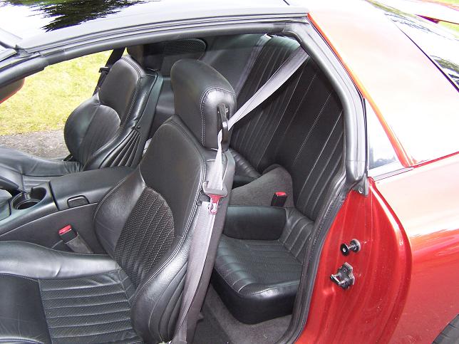 2001 Pontiac Trans Am interior showing black leather front seats and rear seats with seatbelts