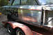 1964 Ford Fairlane - Side view of a car body on a trailer, showing exposed metal and primer.