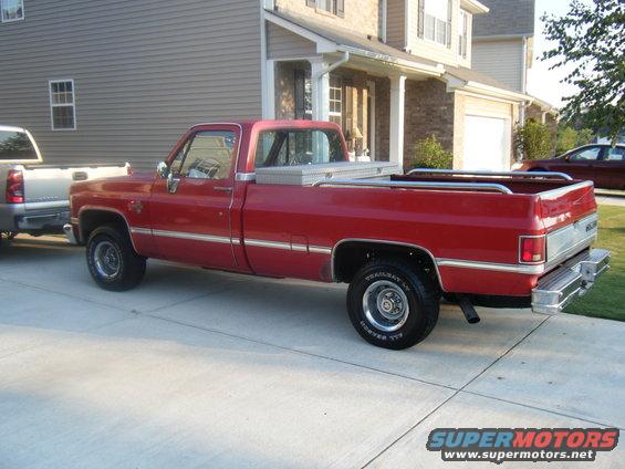 Red pickup truck parked next to a silver pickup truck in a driveway