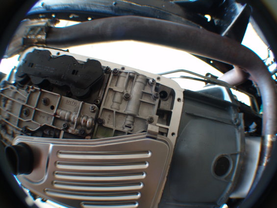 Close-up of a transmission pan with a new filter installed. Some internal transmission components are visible