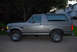 1995 Ford Bronco - This gray Ford Bronco is viewed from the side, showing its distinctive body style and chrome wheels.