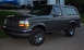 1995 Ford Bronco - This Ford Bronco is parked in front of a house with a boat and another car in the background.