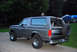 1995 Ford Bronco - This Ford Bronco is parked outside on a paved surface with a grassy area and trees behind it.