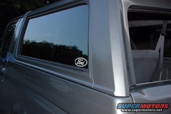 Side view of a gray Ford Bronco with a Ford oval sticker on the rear window