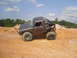 1984 Ford Bronco II - Modified 1984 Ford Bronco II navigates challenging terrain on a dirt hill.