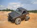 1984 Ford Bronco II - This modified SUV, likely from the early 1980s, is equipped for off-road use with oversized tires and a protective roll cage.