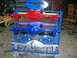 1992 Ford Mustang - Several painted rear axle assemblies are displayed on a blue metal cart in a workshop.