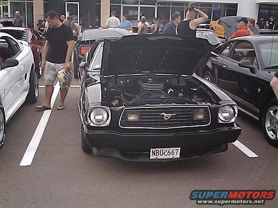 Black 1978 Ford Mustang II front view, hood open, showing engine. License plate NBQ667