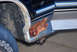 1995 Ford Bronco - Close-up of a rusted lower body panel on a 1995 Ford Bronco, with a tire in view.