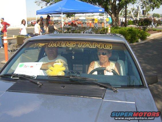 1986 Ford Mustang interior with two people and a yellow stuffed animal