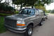 1995 Ford Bronco - Gray 1995 Ford Bronco parked curbside with another vehicle visible behind it.