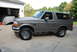 1995 Ford Bronco - Side view of a gray 1995 Ford Bronco parked on a concrete driveway.