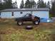 1985 Toyota Pickup/SR5 - This modified 1985 Toyota Pickup features oversized tires and a custom flatbed, parked in a grassy yard.