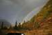 1990 Chevrolet Suburban - A double rainbow appears after a rain shower in a mountainous, wooded area during autumn.