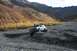1990 Chevrolet Suburban - A white 1990 Chevrolet Suburban navigates a challenging rocky terrain in a mountainous landscape during autumn.
