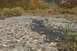 1990 Chevrolet Suburban - A shallow stream flows through a rocky landscape with fall colors visible on the surrounding hills.