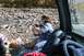 1990 Chevrolet Suburban - A woman eats from a container while sitting inside a vehicle parked near a stream.