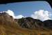 1990 Chevrolet Suburban - Mountain landscape with autumn colors and clouds, viewed from a vehicle window.